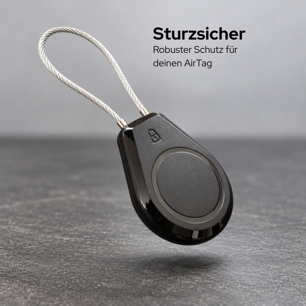 lang-de:AirTag-Halter mit Stahlseil über einem Betonboden